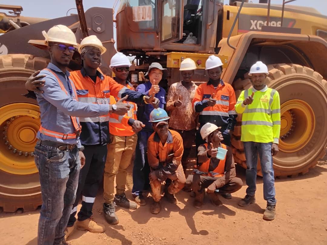 Équipe Logika Africa devant un engin minier